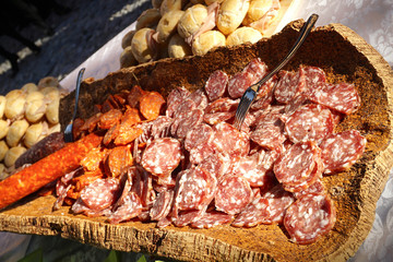 Pane salame e salsiccia su un piatto di legno