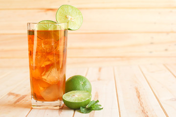 ice tea with slice of lemon in glass on the wooden background