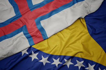Fototapeta premium waving colorful flag of bosnia and herzegovina and national flag of faroe islands.