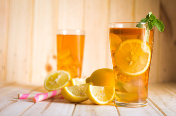 Glasses of ice tea with lemon slices  on wooden background