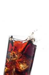 A tall glass with ice and refreshing cola like colored drink.