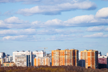 blue sky with clouds over urban multistorey houses