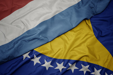 waving colorful flag of bosnia and herzegovina and national flag of luxembourg.