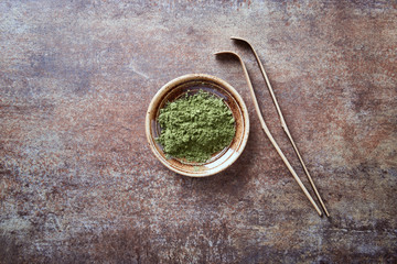Powdered matcha green tea on rustic stone background. Top view. 