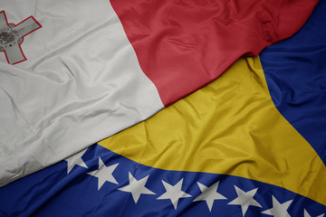 waving colorful flag of bosnia and herzegovina and national flag of malta.