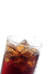 A tall glass with ice and refreshing cola like colored drink.