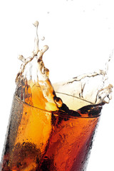 A tall glass with ice and refreshing cola like colored drink.