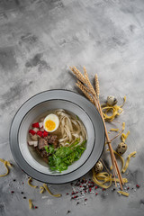 Japanese ramen soup with tofu on dark stone background. Miso soup with ramen noodles and tofu in...