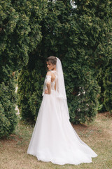 portrait of a bride with flowers in a beautiful full-length wedding dress, young brunette, tender photo wedding portrait