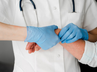 Close-up doctor checking wrist. Pulse and heart rate.