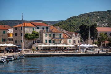Fototapeta na wymiar Panorama, coastline and red roofs of village Postira on island Brac in Croatia