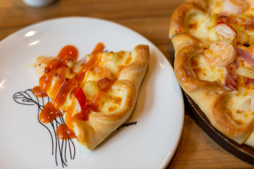 Seafood Italian Pizza slice on wood dish