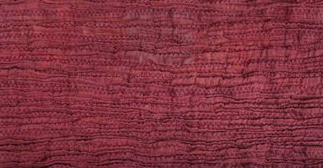 surface of stitched crumpled red brown scarf