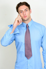 Portrait of young handsome businessman talking on the phone