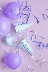 Blue caps, purple balls and silver serpentine on a purple paper background. Holiday background.