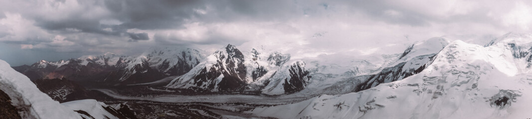 Pamir. Peak of Lenin. Kyrgyzstan. Pan-frame photo. High mountains covered in snow. storm clouds