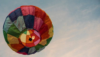  A colorful lantern/balloon is flying in the blue sky with white clouds in the afternoon of Diwali. Indian festival