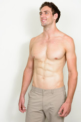Fototapeta premium Portrait of happy young handsome muscular man thinking shirtless