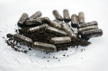 Close up view of Habbatussauda jinten hitam powder extract nigella sativa black seed in capsules,...