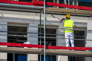 Workers panelling new concrete facade with stone flagstone