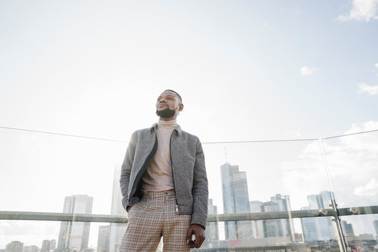 Stylish man standing on observation terrace with skycraper view, Frankfurt, Germany