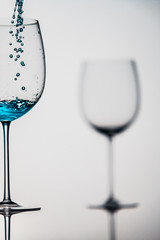 Blue liquid in a glass on bright background