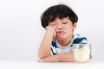 Sad little Asian boy refuses to drink milk