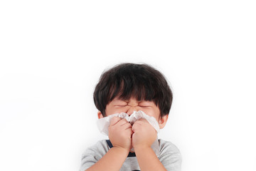 Sick little Asian boy wiping or cleaning nose with tissue isolated white background