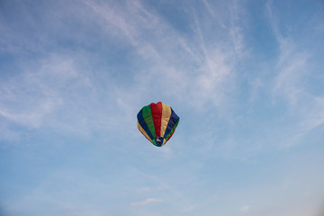  A colorful lantern/balloon is flying in the blue sky with white clouds in the afternoon of Diwali. Indian festival