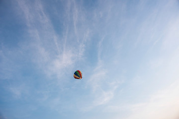  A colorful lantern/balloon is flying in the blue sky with white clouds in the afternoon of Diwali. Indian festival