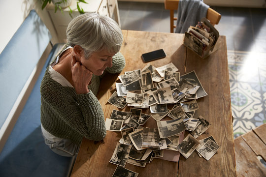 Senior woman watching old photos at home