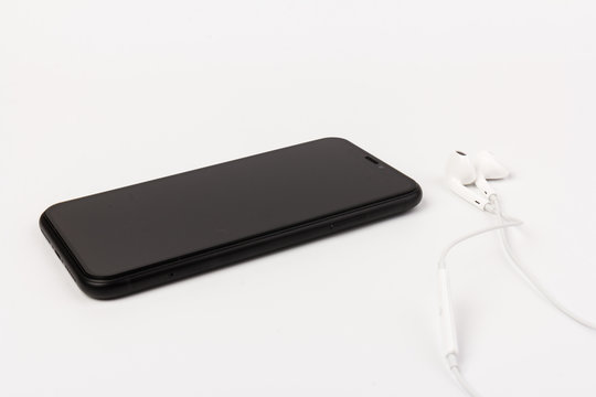 Creative flat lay photo of workspace desk with earphones and mobile phone