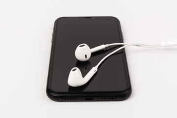 Creative flat lay photo of workspace desk with earphones and mobile phone