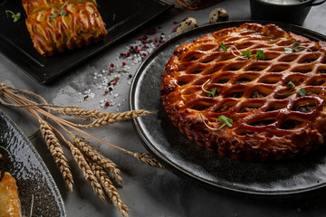 a large cabbage or Apple pie on a dark background and linen sacking. Rustic style. natural material. Wood, glass, fabric