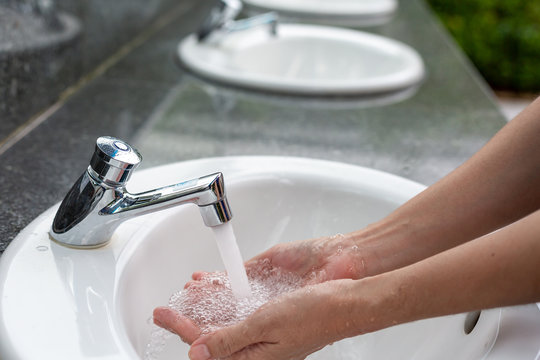Washing hands in water running.