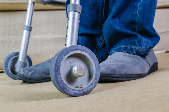 Elderly man using a Zimmer walking frame in his own home