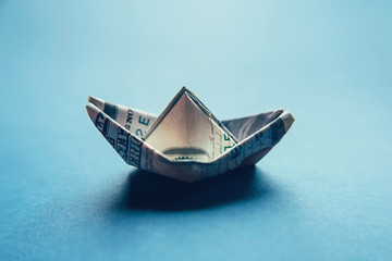 100 dollar bill in the shape of a ship. Financial and economic concept.