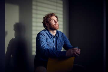 Relaxed casual businessman sitting down with closed eyes