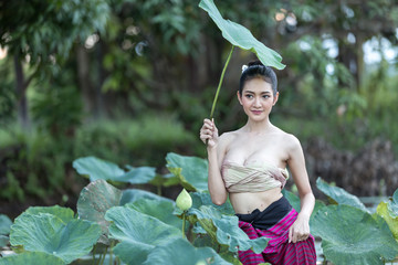 Asian woman harvest lotus flower in the garden,