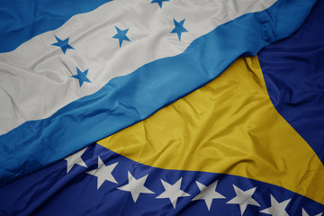 waving colorful flag of bosnia and herzegovina and national flag of honduras.