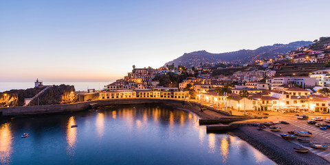Portugal, Madeira, Camara de Lobos, Clear sky over bay of coastal town at dusk