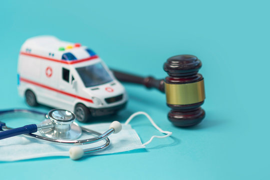 ambulance car and brown gavel stethoscope and on a blue background. symbol photo for bungling and medical error