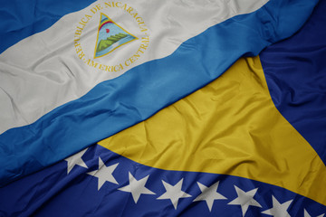 waving colorful flag of bosnia and herzegovina and national flag of nicaragua.
