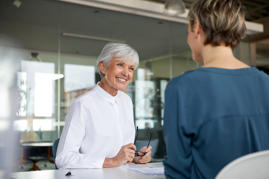 Two businesswomen talking at desk in office