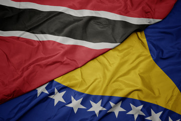 waving colorful flag of bosnia and herzegovina and national flag of trinidad and tobago.