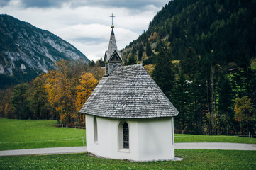 White church with grey roof stand at the foot of the mountains