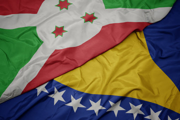 waving colorful flag of bosnia and herzegovina and national flag of burundi .