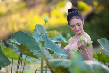 Fotobehang Lotusbloem Asian woman harvest lotus flower in the garden,  © warongdech