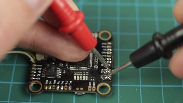 Electronic multimeter tool measuring voltage on ARM digital controller. Close up
