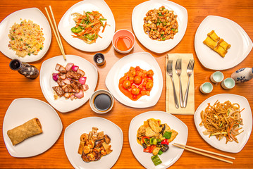 overhead shot of white plates with Chinese food